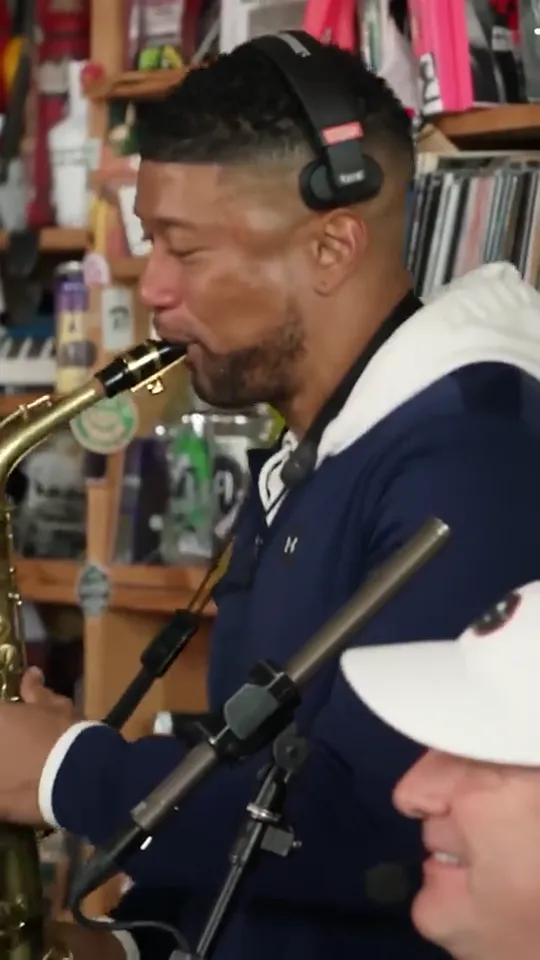 Trend reference: a musician in headphones plays saxophone beside a microphone.